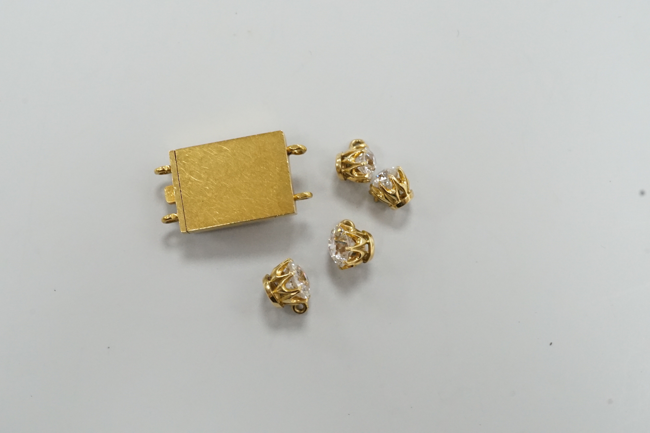 Four yellow metal and diamond set pendants and a diamond set yellow metal clasp.